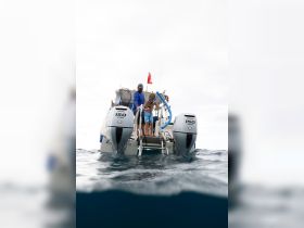 A child and an adult prepare for a snorkeling adventure from a boat, showcasing family fun and water activities in a tropical setting.