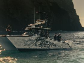 A group of anglers enjoys a fishing trip aboard a stylish boat, casting lines into the shimmering ocean waters — perfect for adventure seekers and fishing enthusiasts.