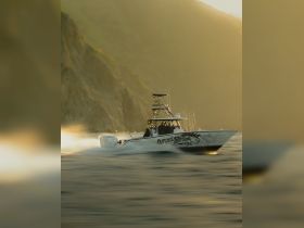 A speedboat named 'Outcast Sportfishing' races through the water, showcasing the thrill of fishing adventures on the open sea.