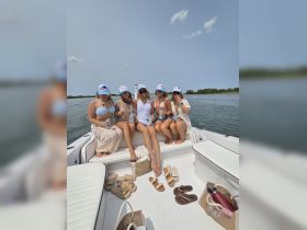 A fun group of friends enjoys a day on the water, celebrating together on a boat with drinks in hand — perfect for summer outings and memorable adventures.