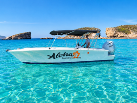 A sleek boat named 'Aloha' navigates through crystal-clear waters, showcasing the beauty of Malta's coastline — perfect for charter adventures.
