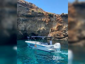 A scenic view of a boat navigating through crystal-clear waters near stunning cliffs, showcasing the beauty of a day on the water.
