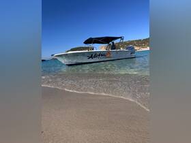 A sleek speedboat named 'Aloha' is anchored in shallow waters, showcasing its design against a stunning coastal backdrop — perfect for exploring Malta's beautiful shores.