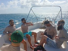 A group of friends relaxes on a boat under the sun, enjoying their time on the water — perfect for a day of fun and camaraderie.