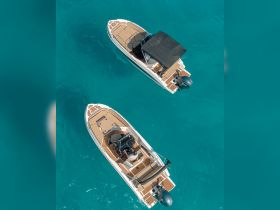 Aerial view of two sleek speedboats cruising through crystal-clear turquoise waters, showcasing the perfect setup for a day of adventure on the water.