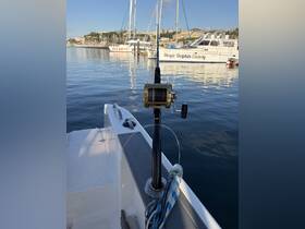Close-up of fishing gear on a boat, featuring a gold reel and fishing rod, perfect for a day of angling in serene waters.