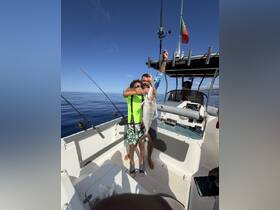 A joyful moment on a fishing trip as a child and adult celebrate their catch aboard a boat, showcasing the excitement of family fishing adventures.