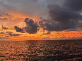 A breathtaking sunset over the ocean, with vibrant colors reflecting on the water — a perfect backdrop for evening boat trips and serene moments at sea.