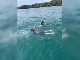 Two individuals enjoy a snorkeling adventure in clear turquoise waters, showcasing the fun and excitement of underwater exploration.