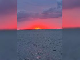 A stunning sunset over the water, showcasing vibrant colors that create a picturesque backdrop for evening boat trips or romantic cruises.