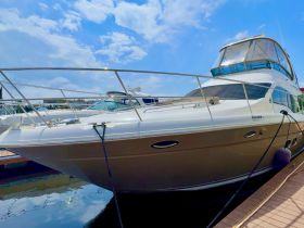 A stunning yacht docked at the marina, showcasing its sleek design and luxurious features under a bright blue sky.