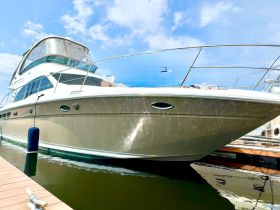 A stunning yacht docked at the marina, showcasing its sleek design and polished exterior under a clear blue sky.