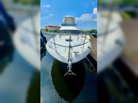 A stunning front view of a yacht docked in calm waters, showcasing its sleek design and polished features — perfect for luxury boating experiences.