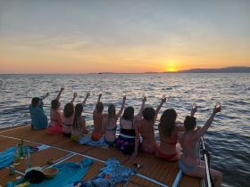A group of friends raises their glasses in celebration as they enjoy a stunning sunset on the water, creating unforgettable memories aboard a boat.