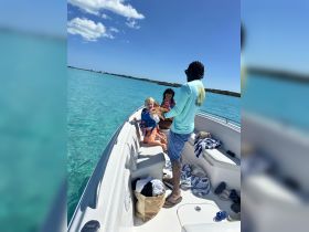 A joyful family enjoys a day on the water, with children playing and exploring on the boat — a perfect snapshot of fun and adventure in the sun.