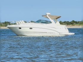 A sleek Chaparral yacht glides through calm waters, showcasing its elegant design and perfect for leisurely outings on the water.