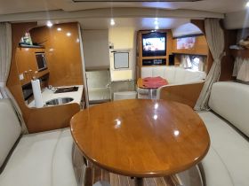 Interior view of a boat cabin featuring a cozy dining area and modern amenities, perfect for relaxing and entertaining while on the water.