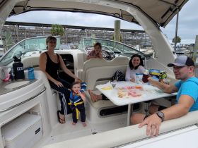 A joyful family enjoys snacks and drinks inside their boat, creating memorable moments together. Perfect for family outings on the water.