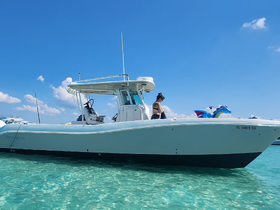 A person stands on a boat in clear turquoise waters, showcasing a perfect day for boating and water activities.