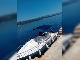 A sleek speedboat docked by the shore, perfect for rental adventures on the water. Enjoy the serene views and explore the coastline with this stylish vessel.