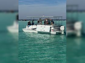 A lively group enjoys a day on the water aboard a boat, capturing moments of fun and togetherness in the beautiful turquoise waters.