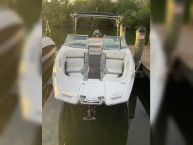 A sleek speedboat docked at a marina, showcasing its modern design and spacious seating — perfect for a day on the water.
