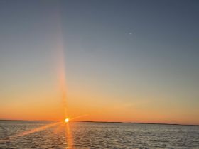A stunning sunset over calm waters, capturing the serene beauty of a boating experience. Perfect for those seeking picturesque views on the water.