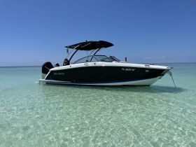 A sleek Cobalt boat anchored in crystal-clear waters, showcasing its elegant design against a stunning blue sky — perfect for summer outings and water adventures.