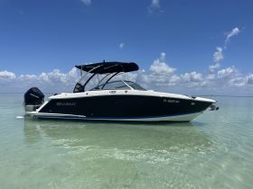 A sleek Cobalt boat anchored in shallow waters under a clear blue sky, showcasing its elegant design and perfect for a day on the water.