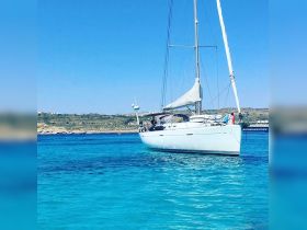 A beautiful sailboat glides through crystal-clear turquoise waters, showcasing the perfect setting for a serene day on the sea.