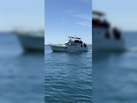 A sleek yacht cruises through clear waters, showcasing its elegant design and perfect for a day on the sea.