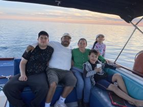 A joyful family enjoys a sunset boat ride, creating lasting memories together on the water.