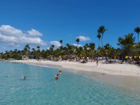 A vibrant beach scene with people swimming and enjoying the sun, showcasing the perfect vacation spot for relaxation and fun in the water.