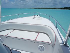 A pristine view of the seating area on a boat, showcasing comfortable cushions against a backdrop of stunning turquoise waters — perfect for relaxing on a day out at sea.