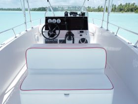 The interior of a sleek boat helm featuring modern controls and comfortable seating, perfect for navigating the open waters.