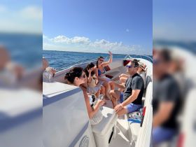 A lively group enjoys a fun day on the water, sharing drinks and laughter aboard a boat, perfect for celebrations and memorable outings.