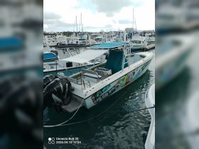 A vibrant speedboat named 'Cool Runnings' docked at a marina, showcasing its colorful design and sleek structure against a backdrop of other vessels.
