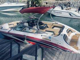 A sleek Yamaha speedboat docked at a marina, showcasing its stylish design and comfortable seating — perfect for thrilling water adventures.
