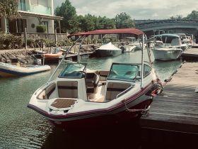A sleek speedboat docked at a marina, showcasing its stylish design and inviting seating area, perfect for a day on the water.