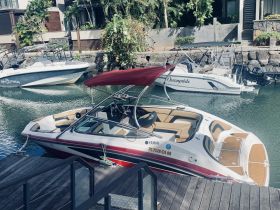 A sleek Yamaha boat docked in a serene marina, showcasing its elegant design and inviting interior — perfect for leisurely outings on the water.