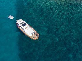 A lively group enjoys a day on the water aboard a boat, surrounded by crystal-clear turquoise waters — perfect for summer adventures and relaxation.