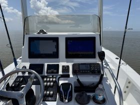A detailed view of the helm and console of a fishing boat, showcasing advanced navigation and communication equipment — perfect for anglers and boating enthusiasts.