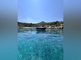A picturesque view of a boat anchored in crystal-clear waters, surrounded by lush greenery and rocky terrain, perfect for exploring hidden coves.