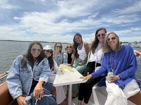 A joyful group of friends enjoys a day on the water, celebrating together aboard a boat — perfect for memorable outings and gatherings.