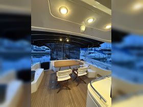 A cozy interior view of a boat's dining area featuring elegant seating and a polished wooden table, perfect for relaxing meals on the water.