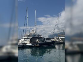 A beautiful yacht docked at a marina, surrounded by other vessels under a clear blue sky — perfect for luxury boating experiences.