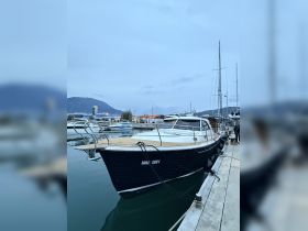 A sleek yacht docked at the marina, showcasing its elegant design against a tranquil evening backdrop.
