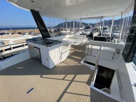 A spacious interior view of a modern yacht's helm and seating area, showcasing a stylish and comfortable design perfect for relaxing on the water.