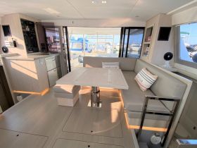 A spacious and modern interior of a boat featuring comfortable seating and a well-equipped helm area, perfect for relaxing or navigating during your maritime adventures.