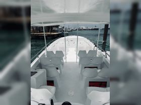 Interior view of a spacious boat cabin featuring white seating and a clean layout, ideal for group outings or charters.
